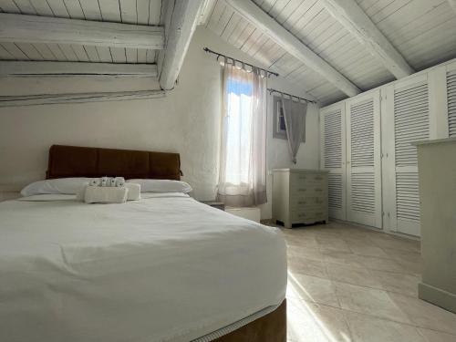 Un dormitorio con una gran cama blanca y una ventana en Punta Est Trilocale Splendida Vista Mare, en Capo Coda Cavallo