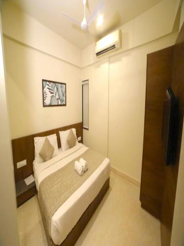 a bedroom with a bed and a television in it at Hotel Pine Tree in Rajkot