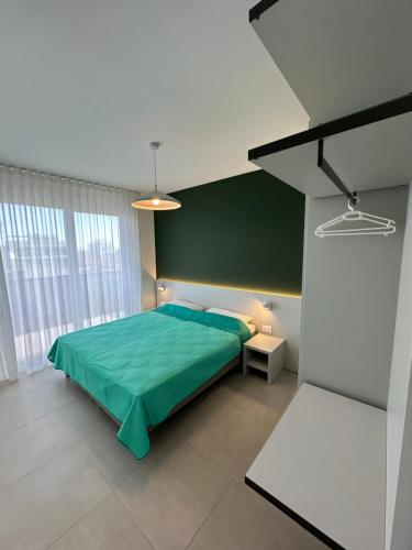 una camera con un letto verde con una coperta verde di Woody Green Charming Apartments - Agenzia Cocal a Caorle