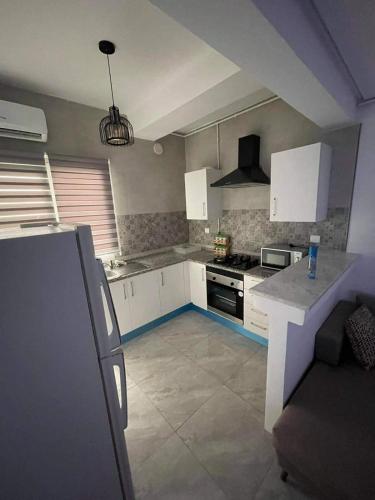 a kitchen with white cabinets and a stove at Zayatin in El Aouina