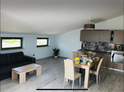 uma sala de estar e cozinha com uma mesa e um sofá em Appartamento vista mare a Trebisacce em Trebisacce