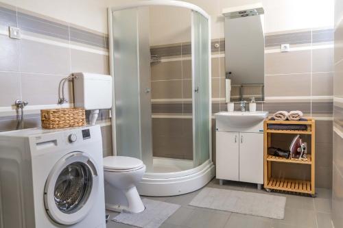 une salle de bain avec un lavabo et une machine à laver dans l'établissement Spacious Studio Close to City Center l Double Bed l Secure Bicycle Parking, à Novi Sad