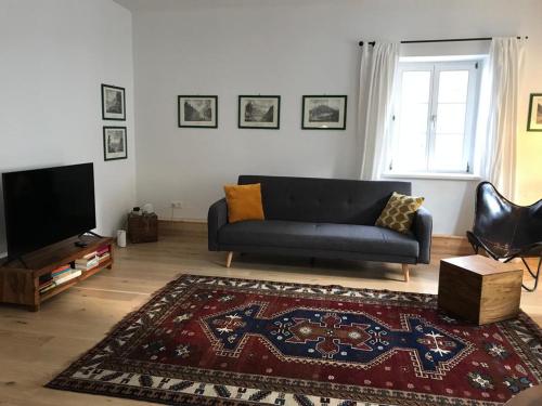 een woonkamer met een bank en een televisie bij Schön wohnen beim Stift in Melk