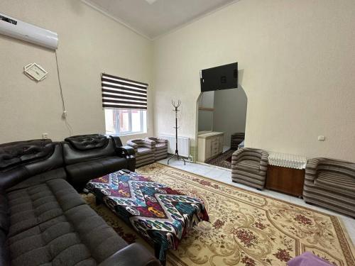 a living room with a couch and a television at HOSTEL NABI BOBO in Samarkand