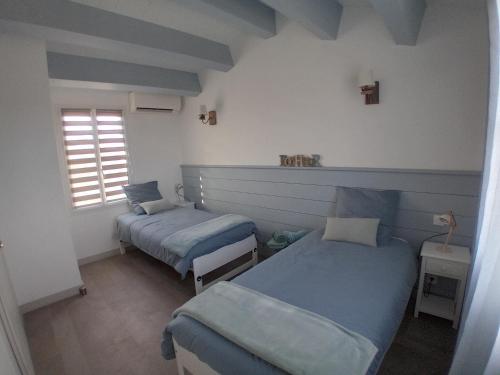 a room with two beds and a window at Maison de charme La Flotte en Ré in La Flotte