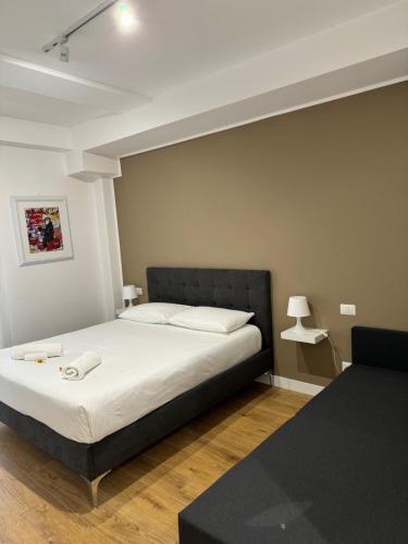 Schlafzimmer mit einem Bett mit einem schwarzen Kopfteil in der Unterkunft Titina Suites Apartment Rome in Rom