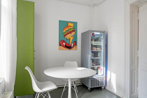 eine Küche mit einem weißen Tisch und einem Kühlschrank in der Unterkunft Nest Boutique Hostel in Bukarest