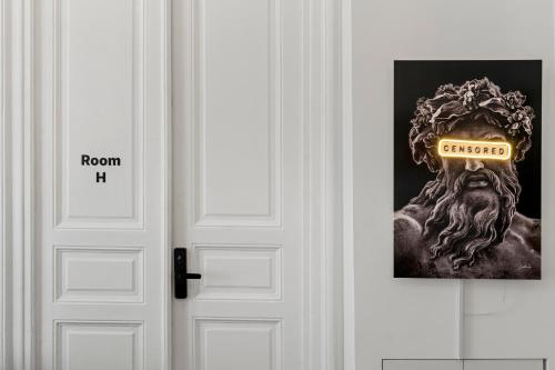 a door with a picture of a man with a sign on it at Nest Boutique Hostel in Bucharest
