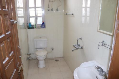 a bathroom with a toilet and a sink at Rashmi Cottage in Dagshai