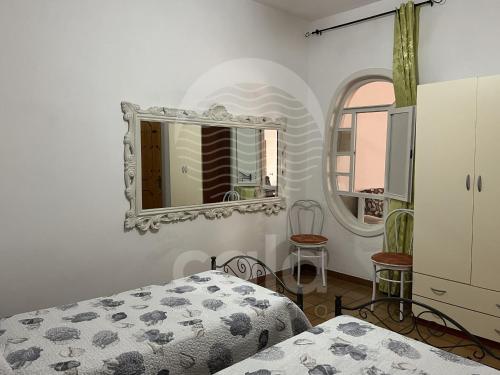 a bedroom with a bed and a mirror at Villetta Zora - Spiaggia a 250m in Porto Cesareo