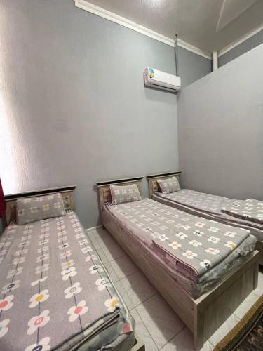 two beds sitting next to each other in a room at HOSTEL NABI BOBO in Samarkand