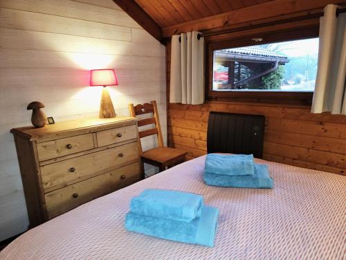 a bedroom with a bed with two blue towels on it at Chalet Pura Vida - En pleine nature, tout confort in Le Valtin