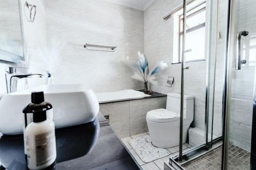 a bathroom with a sink and a toilet and a shower at Azure Escape - Power backup in Sandton