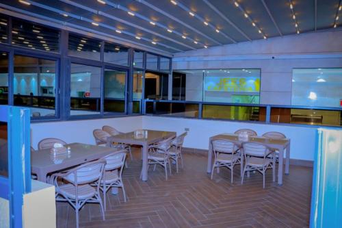 a restaurant with tables and chairs and a bar at Jees Hotel in Hargeysa