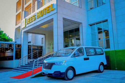 a white van parked in front of a building at Jees Hotel in Hargeysa
