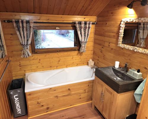 La salle de bains est pourvue d'une baignoire et d'un lavabo. dans l'établissement Chalet Pura Vida - En pleine nature, tout confort, à Le Valtin