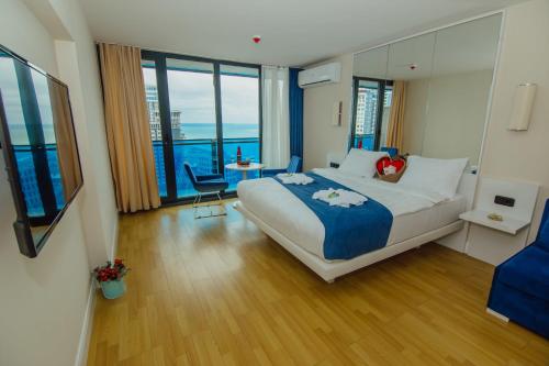 バトゥミにあるOrbi City Beach Hotel Batumiの大きなベッドとテーブルが備わるホテルルームです。