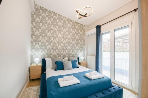 - une chambre avec un lit bleu et une grande fenêtre dans l'établissement Beach Blue Villa, à Corinthe