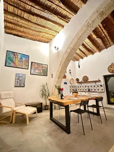 una cucina con tavolo e sedie in una stanza di The Hermitage: Timeless charm&Beach&History nearby a Yenibosazici