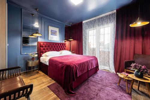 a bedroom with a red bed and a table at Apartments Marant - free private parking in Zadar