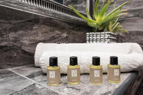 four bottles of essential oils on a counter next to a towel at Apartments Marant - free private parking in Zadar