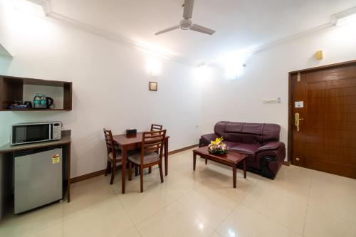 a living room with a couch and a table at Lords Midtown Suites Bangalore in Bengaluru