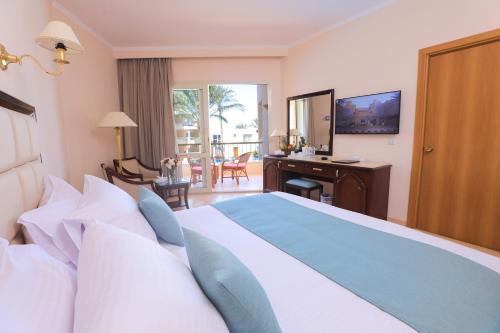 a hotel room with a bed and a desk with a view at Sea Star Beau Rivage Hotel in Hurghada