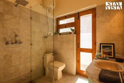 a bathroom with a toilet and a shower and a sink at StayVista's Fiddle Leaf Home - Elegant Interiors, Spacious Lawn & Inviting Balcony in Amritsar
