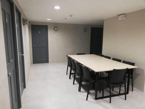 a conference room with a table and black chairs at Manila Real Residences Studio 8C in Manila