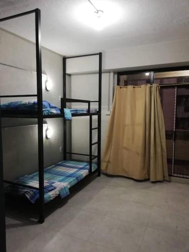 a room with three bunk beds and a curtain at Manila Real Residences Studio 8C in Manila