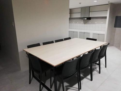a dining room with a table and black chairs at Manila Real Residences Studio 8C in Manila