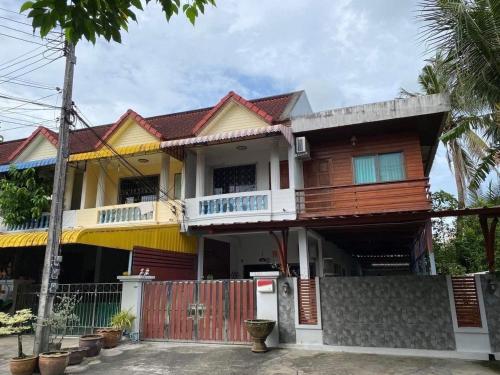 a wooden house with a fence in front of it at Pani House ( Hatyai 2 ) in Hat Yai
