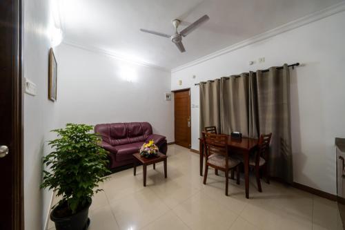 a living room with a couch and a table at Lords Midtown Suites Bangalore in Bengaluru