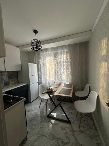 a kitchen with a table and chairs in a kitchen at Однокомнатная квартира в центре города in Uralsk