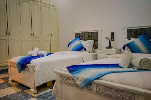 a bedroom with two beds with blue and white at IDGA appartement with panoramic view in Chefchaouen