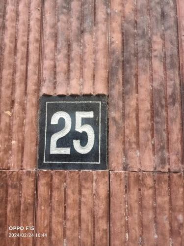 a sign on the side of a building with the number at 25 guest house in Puducherry