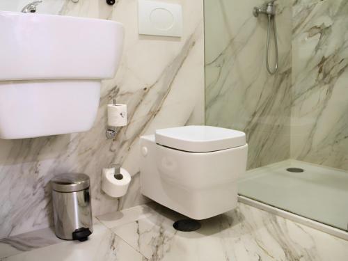 a white bathroom with a toilet and a shower at Bemyguest - Loft Guest House Jardim das Mães Charming in Viseu