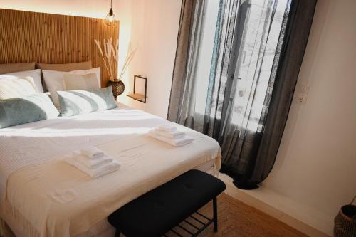 1 dormitorio con 1 cama grande y toallas. en NISOS Home Stay en Mykonos