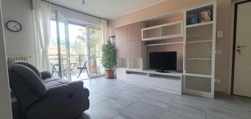 een woonkamer met een bank en een televisie bij Appartamento Matilde. Spazio, comodità e relax! in Gavirate