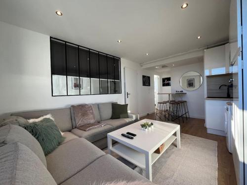 un salon avec un canapé et une table dans l'établissement Appartement Standing 3ch 3SdB, à Toulouse