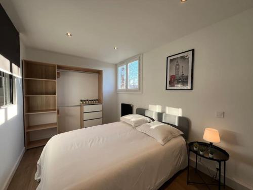 une chambre avec un grand lit blanc et une fenêtre dans l'établissement Appartement Standing 3ch 3SdB, à Toulouse