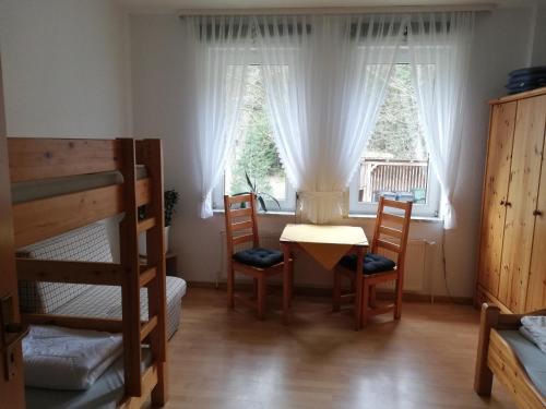 een kamer met een tafel en stoelen en een raam bij Harzklub Wanderheim in Wildemann
