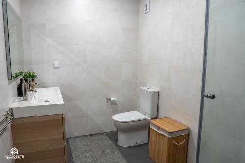 a white bathroom with a toilet and a sink at Navio Beach Apartment Santa Cruz in Santa Cruz