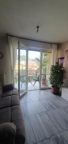 een woonkamer met een bank en een glazen schuifdeur bij Appartamento Matilde. Spazio, comodità e relax! in Gavirate