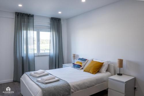 a bedroom with a bed with yellow pillows and a window at Navio Beach Apartment Santa Cruz in Santa Cruz