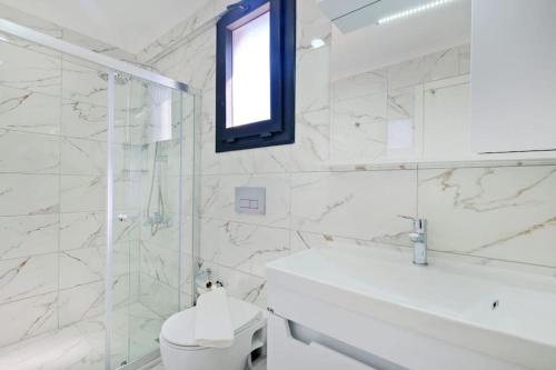 a white bathroom with a toilet and a sink at Villa Simge 3+1 Ölüdeniz in Fethiye