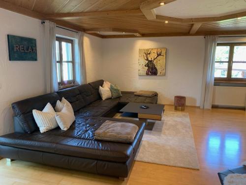 a living room with a leather couch and a table at Habicht Ferienhaus in Arnbruck