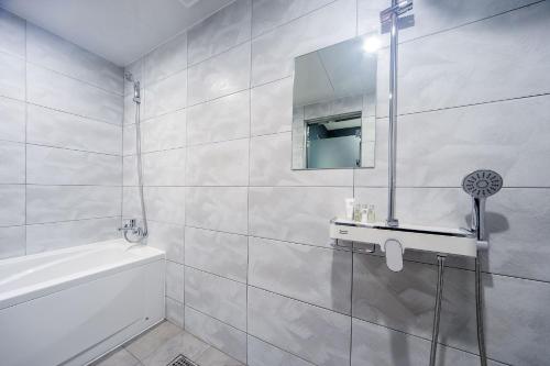La salle de bains blanche est pourvue d'un lavabo et d'un miroir. dans l'établissement ON:NA Hotel, à Busan
