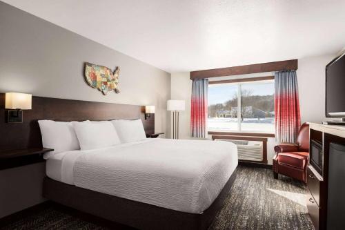 a hotel room with a bed and a window at Ramada by Wyndham Richland Center in Richland Center