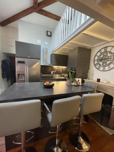une cuisine avec un grand comptoir et des chaises. dans l'établissement Charmant appart au cœur de Paris, à Paris